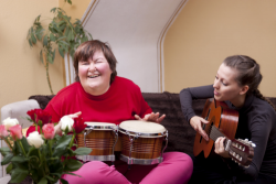 a girl and her caretaker happily playing musical instruments